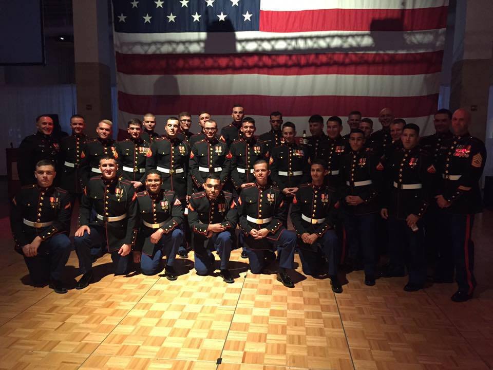 Marines in dress blues under the American flag